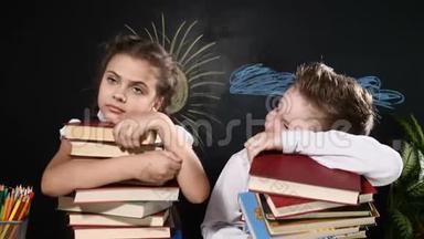 学校观念。 可爱的男孩和迷人的女孩坐着<strong>一堆书</strong>。 学童坐在<strong>书</strong>桌旁。 后面的黑板